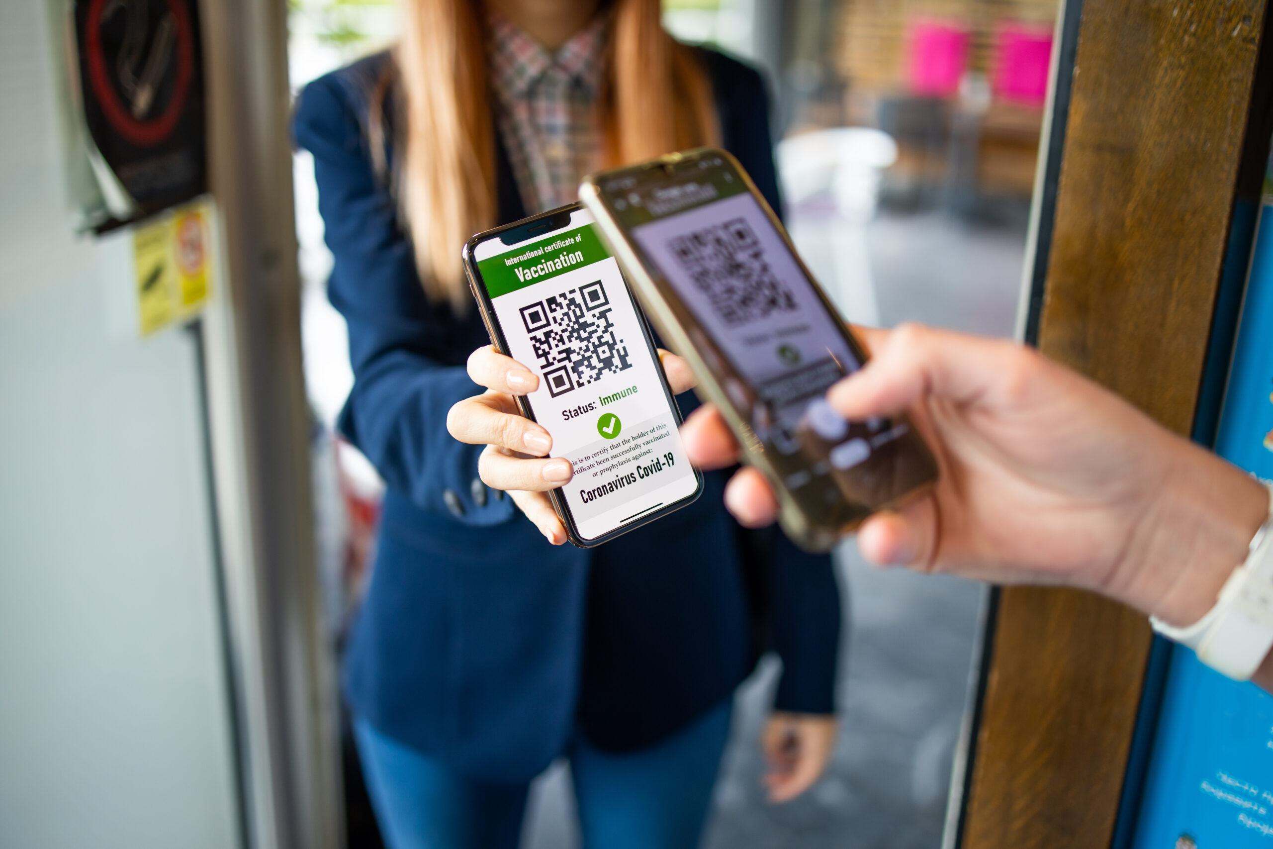 A young woman shows a digital covid passport when entering a res
